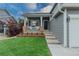 Charming front porch with brick accents, white pillars, and a well-manicured lawn at 9884 Sydney Ln, Highlands Ranch, CO 80130