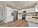 Well-lit kitchen featuring stainless steel appliances, white cabinetry, and wood flooring at 9884 Sydney Ln, Highlands Ranch, CO 80130