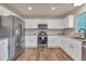 Modern kitchen features stainless steel appliances, white cabinets, granite countertops, and a stylish backsplash at 9884 Sydney Ln, Highlands Ranch, CO 80130