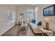 Inviting living room features lots of natural light, vaulted ceilings, wood floors, and modern decor at 9884 Sydney Ln, Highlands Ranch, CO 80130