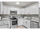 Modern kitchen with white shaker cabinets, granite countertops, and stainless steel appliances at 595 S Alton Way # 5D, Denver, CO 80247