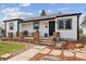 Charming home featuring a cozy front porch with stone accents and a well-manicured landscaped front yard at 2120 Oak Pl, Thornton, CO 80229