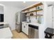 Close-up of kitchen area, featuring stainless steel appliances, open shelving, and a functional layout at 2120 Oak Pl, Thornton, CO 80229