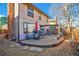Private backyard features a patio with dining set, grill, and mature trees for outdoor enjoyment at 8737 Garrison Ct, Arvada, CO 80005