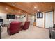Spacious basement features wood ceilings, comfortable seating, and multiple TVs at 8737 Garrison Ct, Arvada, CO 80005