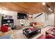 Finished basement with wooden ceiling, TV, sofas, and track lighting at 8737 Garrison Ct, Arvada, CO 80005
