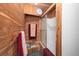 Bathroom highlighted by wood paneling, complete with a glass-enclosed shower and a towel rack at 8737 Garrison Ct, Arvada, CO 80005