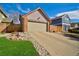 Charming home featuring a two-car garage, brick facade, and driveway at 8737 Garrison Ct, Arvada, CO 80005