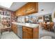 Cozy kitchen featuring wood cabinets, brick accents, and seamless access to the dining and living areas at 8737 Garrison Ct, Arvada, CO 80005