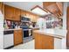 Well-equipped kitchen featuring oak cabinets, stainless steel appliances, and a cozy breakfast bar area at 8737 Garrison Ct, Arvada, CO 80005