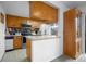 Efficient kitchen featuring oak cabinetry, stainless steel appliances, and a functional breakfast bar at 8737 Garrison Ct, Arvada, CO 80005