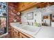 Kitchen sink area with brick surround, vintage cabinets and stainless steel appliances at 8737 Garrison Ct, Arvada, CO 80005