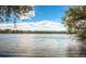 Scenic lake view with a serene water expanse and lush shoreline greenery under a sky filled with clouds at 8737 Garrison Ct, Arvada, CO 80005