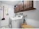 Efficient laundry area equipped with modern machines and overhead storage cabinets at 8737 Garrison Ct, Arvada, CO 80005