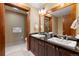 Bathroom featuring double sinks, with dark cabinets, black granite countertops, and plenty of counter space at 1521 Ski Hill Rd # 8313, Breckenridge, CO 80424