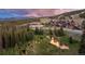 Ski resort exterior surrounded by a forest with a river and mountain views in the background at 1521 Ski Hill Rd # 8313, Breckenridge, CO 80424