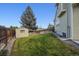 Well-maintained backyard with lush green grass, wooden fence, and shed at 8229 S Ogden Cir, Littleton, CO 80122