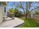 Spacious backyard with a concrete patio, mature trees, and a wood fence at 8229 S Ogden Cir, Littleton, CO 80122