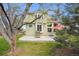 Backyard view showcasing patio, green lawn, mature trees, and the back of the house at 8229 S Ogden Cir, Littleton, CO 80122
