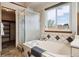 Well-lit bathroom with a tiled bath, separate shower, and modern fixtures at 8229 S Ogden Cir, Littleton, CO 80122