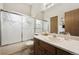 Bathroom featuring shower/tub with decorative glass door and wooden vanity at 8229 S Ogden Cir, Littleton, CO 80122
