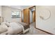Bright bedroom with en-suite bathroom featuring a window, closet, and a comfortable bed at 8229 S Ogden Cir, Littleton, CO 80122