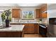 Well-lit kitchen featuring wood cabinets, granite countertops, and stainless-steel appliances at 8229 S Ogden Cir, Littleton, CO 80122