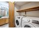 Convenient laundry area adjacent to a half-bathroom, complete with modern washer and dryer at 8229 S Ogden Cir, Littleton, CO 80122