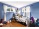Blue-walled bedroom with hardwood floors, ample natural light, and space for relaxation and creativity at 400 W Midway Blvd, Broomfield, CO 80020