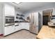 Functional kitchen with stainless steel appliances, white cabinetry, and a view of the adjacent breakfast area at 400 W Midway Blvd, Broomfield, CO 80020