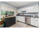Kitchen featuring plenty of storage, stainless appliances, a black rolling island and a light-filled window view at 400 W Midway Blvd, Broomfield, CO 80020