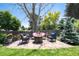 Backyard patio seating area with a swing and a fire pit, surrounded by trees and grass at 6474 W Canyon Ave, Littleton, CO 80128