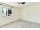 Empty bedroom with neutral colors and carpeted floors, with a window providing natural light and a view outside at 6474 W Canyon Ave, Littleton, CO 80128