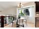 Charming dining area with large window, modern chandelier, and views of the landscaped backyard at 6474 W Canyon Ave, Littleton, CO 80128