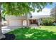 Charming home featuring a manicured lawn, beautiful brickwork, and lovely front yard landscaping at 6474 W Canyon Ave, Littleton, CO 80128