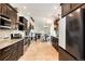 Modern kitchen with stainless steel appliances, granite countertops, and a view of the living area at 6474 W Canyon Ave, Littleton, CO 80128