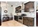 Well-equipped kitchen with dark wood cabinets, stainless steel appliances, and tiled backsplash at 6474 W Canyon Ave, Littleton, CO 80128