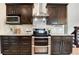 Gourmet kitchen with stainless steel appliances, granite countertops, and custom cabinetry at 6474 W Canyon Ave, Littleton, CO 80128