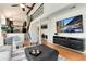 Bright living room featuring hardwood floors, a large screen television, and an open staircase to the second floor at 6474 W Canyon Ave, Littleton, CO 80128