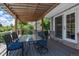 Covered patio with wooden supports, table with blue chairs, and a view of the fenced-in yard at 6474 W Canyon Ave, Littleton, CO 80128
