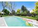 Refreshing swimming pool with floats, surrounded by lush greenery and a well-maintained lawn at 6474 W Canyon Ave, Littleton, CO 80128
