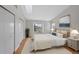 Bright bedroom featuring a large window, hardwood floors, and a comfortable bed with decorative pillows at 1818 S Quebec Way # 7-8, Denver, CO 80231