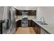 Modern kitchen with stainless steel appliances, granite countertops, and dark wood cabinetry at 1818 S Quebec Way # 7-8, Denver, CO 80231