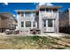 Backyard patio with outdoor furniture, a well-maintained lawn, and a gray home exterior under a bright sky at 16240 E 119Th Ave, Commerce City, CO 80022