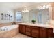 Primary bath with soaking tub, dual sinks, tile accents, and plant for decor at 16240 E 119Th Ave, Commerce City, CO 80022