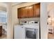 Convenient laundry room area with washer, dryer, and cabinets, plus an open door to a nearby bathroom at 16240 E 119Th Ave, Commerce City, CO 80022