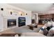 Inviting living room featuring a cozy fireplace and an open layout that seamlessly connects to the kitchen and dining area at 16240 E 119Th Ave, Commerce City, CO 80022