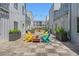 Inviting courtyard featuring colorful Adirondack chairs around a modern fire pit on a wooden-planked patio at 2530 Lawrence St # Ra301, Denver, CO 80205