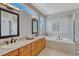 Bright bathroom features double sinks, soaking tub, and neutral tile at 581 Stonemont Dr, Castle Pines, CO 80108