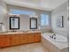 Bright bathroom features double sinks, soaking tub, and neutral tile at 581 Stonemont Dr, Castle Pines, CO 80108